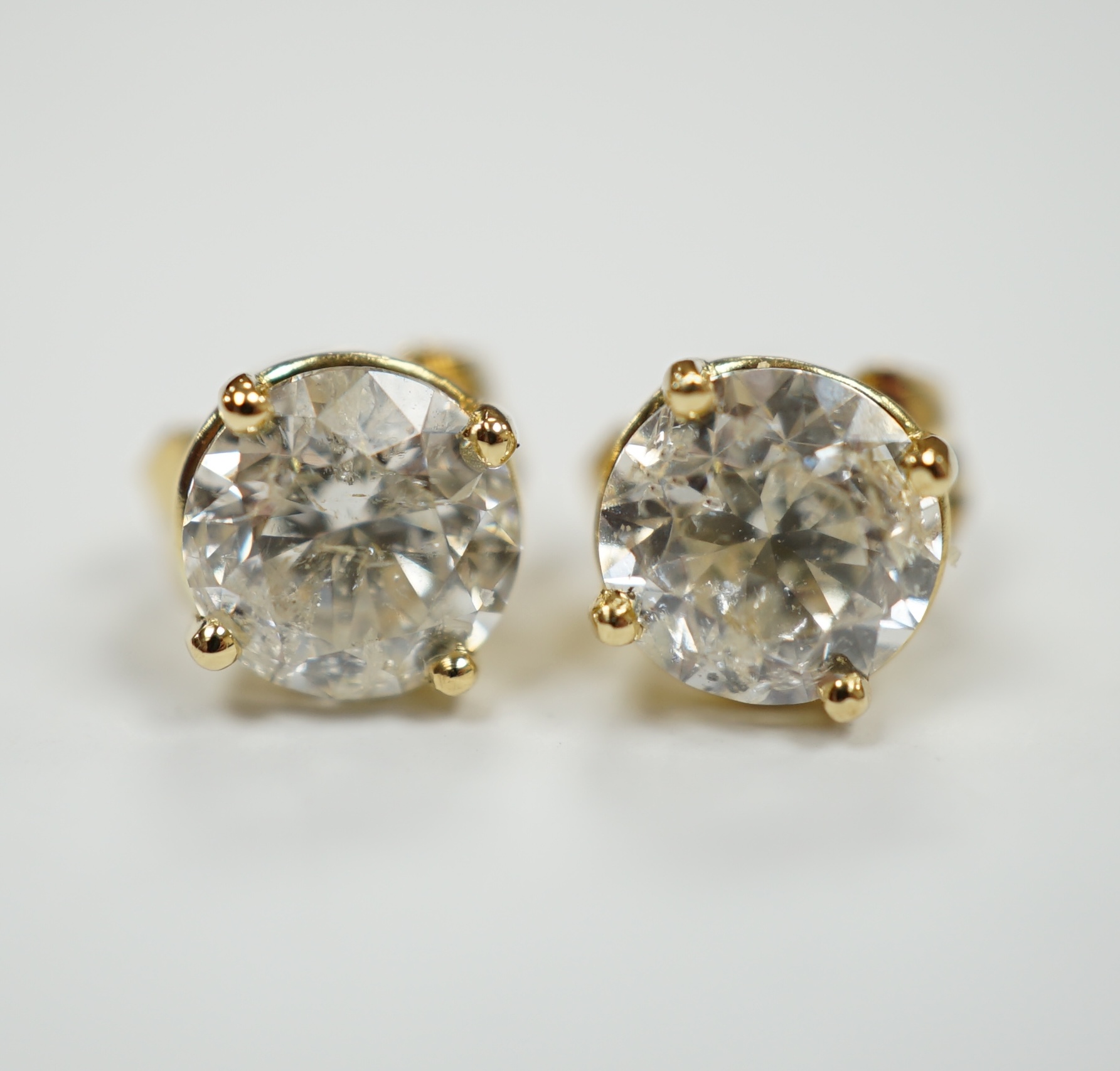 A pair of 750 yellow metal and solitaire diamond set ear studs, with a total carat weight of approximately 1.80ct.